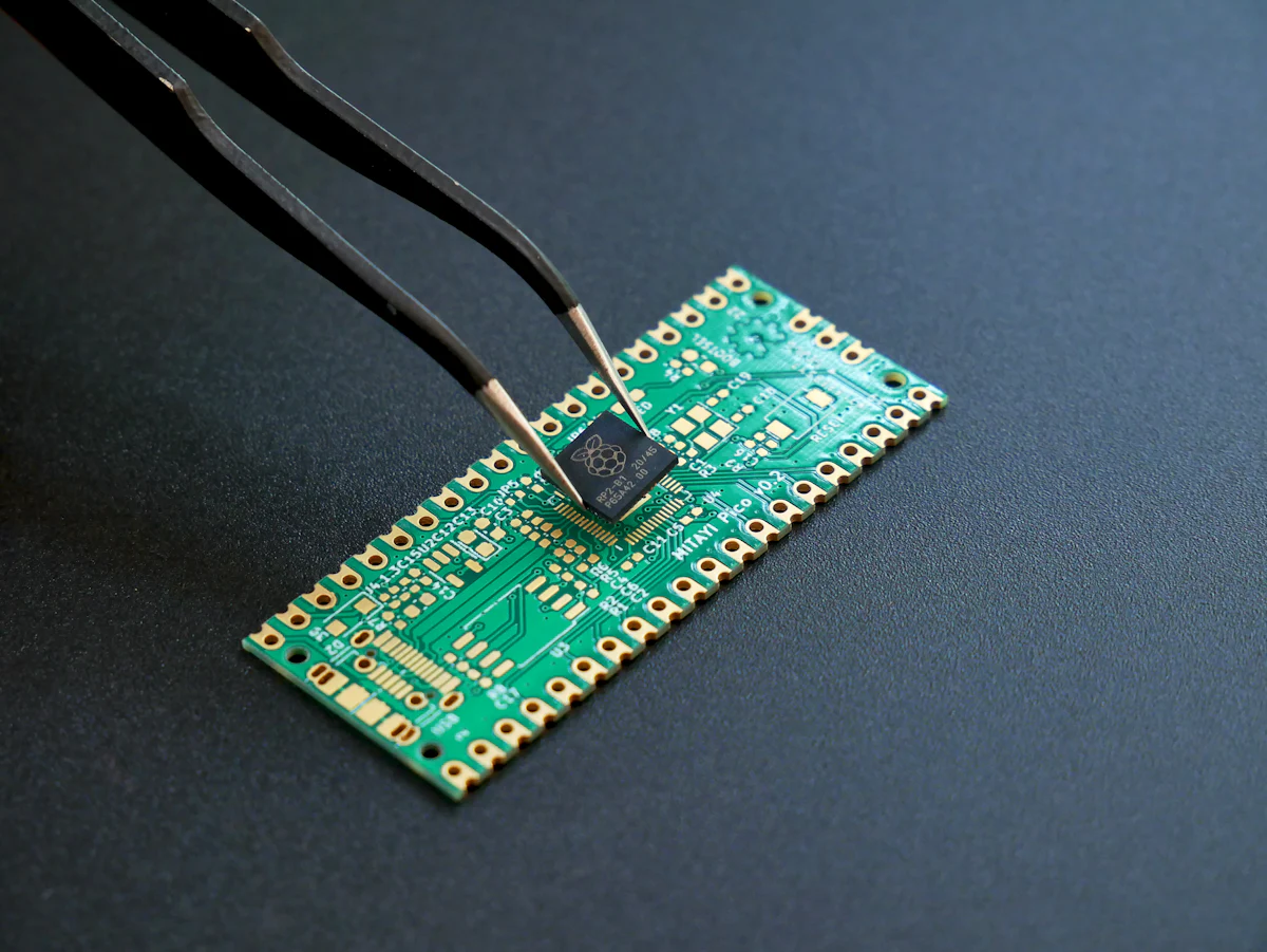 Tweezers placing a microchip onto a printed circuit board